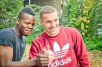 Lukas Podolski macht ein Foto mit einem afrikanischen Jungen