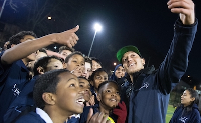 Hilfsorganisation Laureus Sport for Good - Mesut Özil mach ein Foto mit hilfsbedürftigen Kindern.