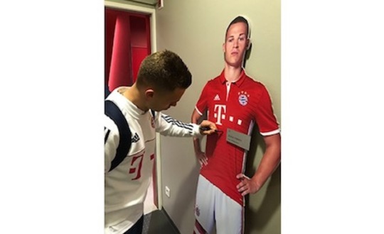 Joshua Kimmich signs his life-size-cut-out figure from the FC Bayern Erlebniswelt