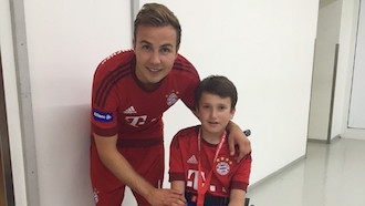 Mario Götze macht ein Foto mit einem Kind im Rollstuhl