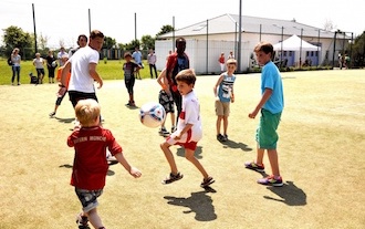 Children play football on the football pitch of the Anton Schrobenhauser Foundation